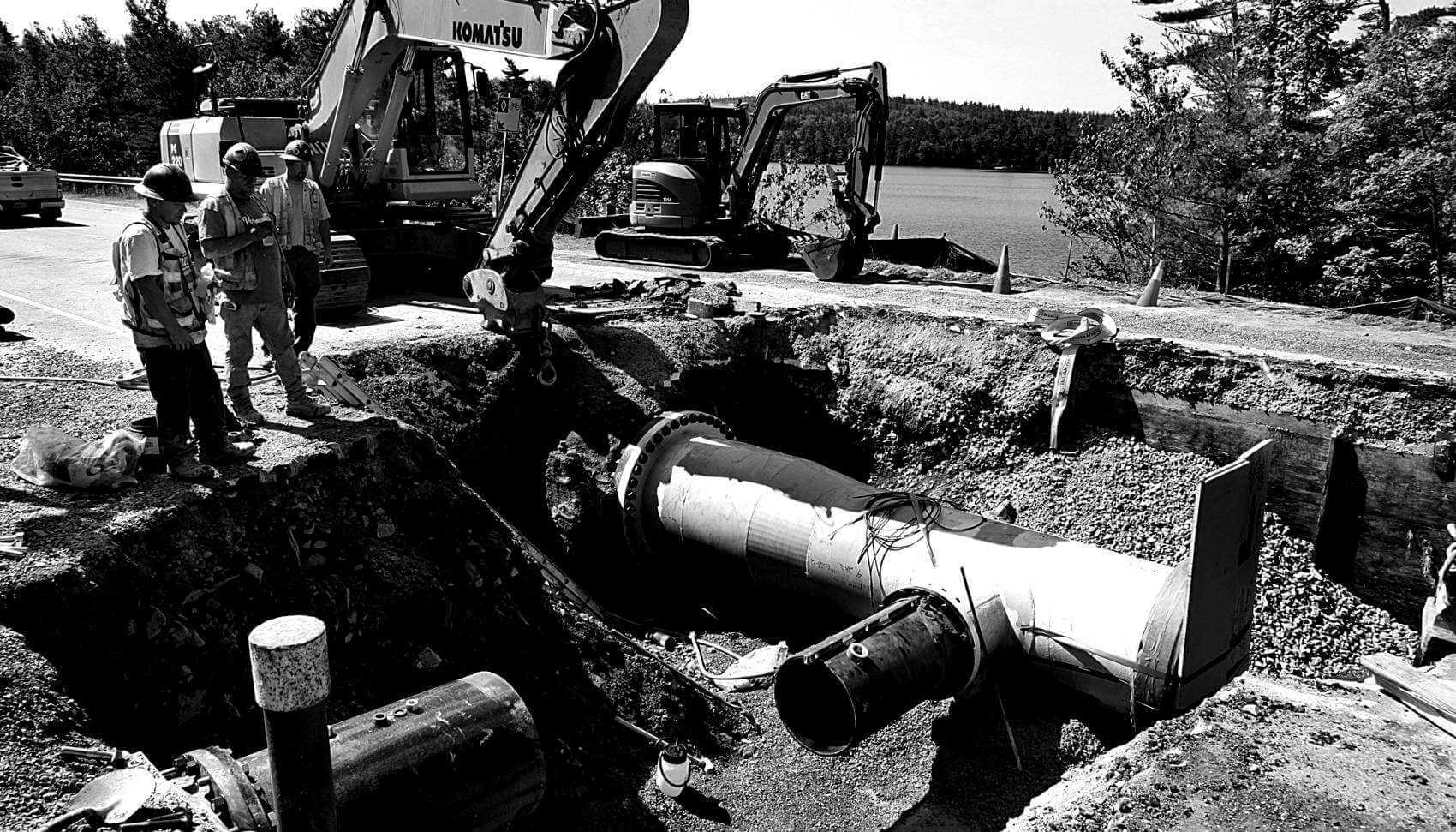 Crew standing near pipe