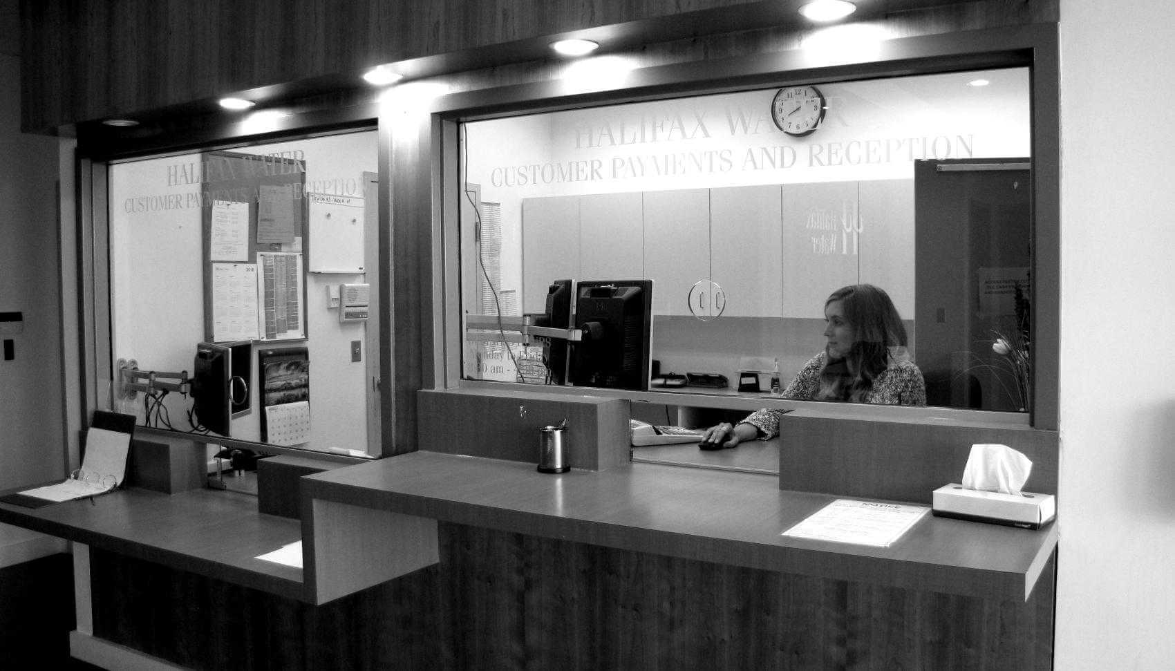 A Halifax Water Customer Care Rep sitting at the front desk at Halifax Water