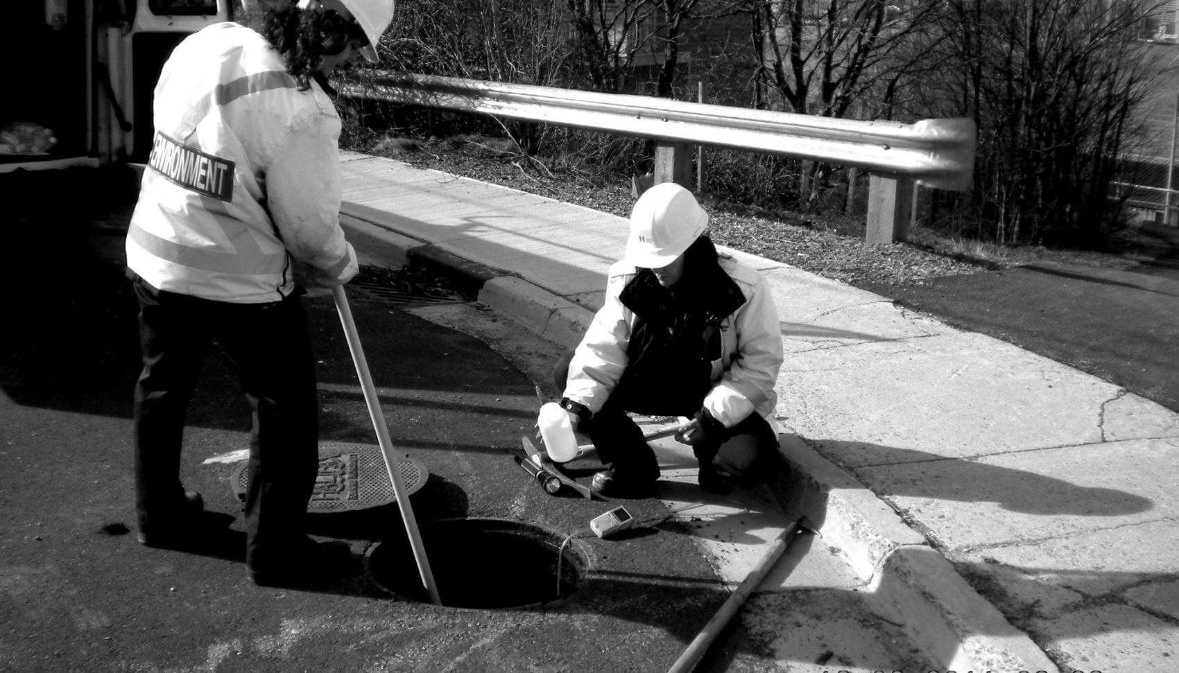 Halifax WEater employees getting a wastewater sample from a manhole